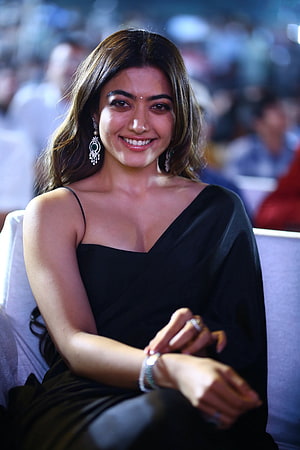 Rashmika Mandanna in an elegant black gown with statement jewelry at a public event HD phone wallpaper