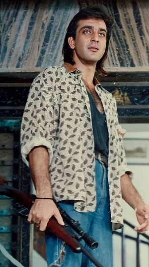 Sunny Deol in a patterned shirt holding a rifle, intense expression, vintage Bollywood action scene HD phone wallpaper