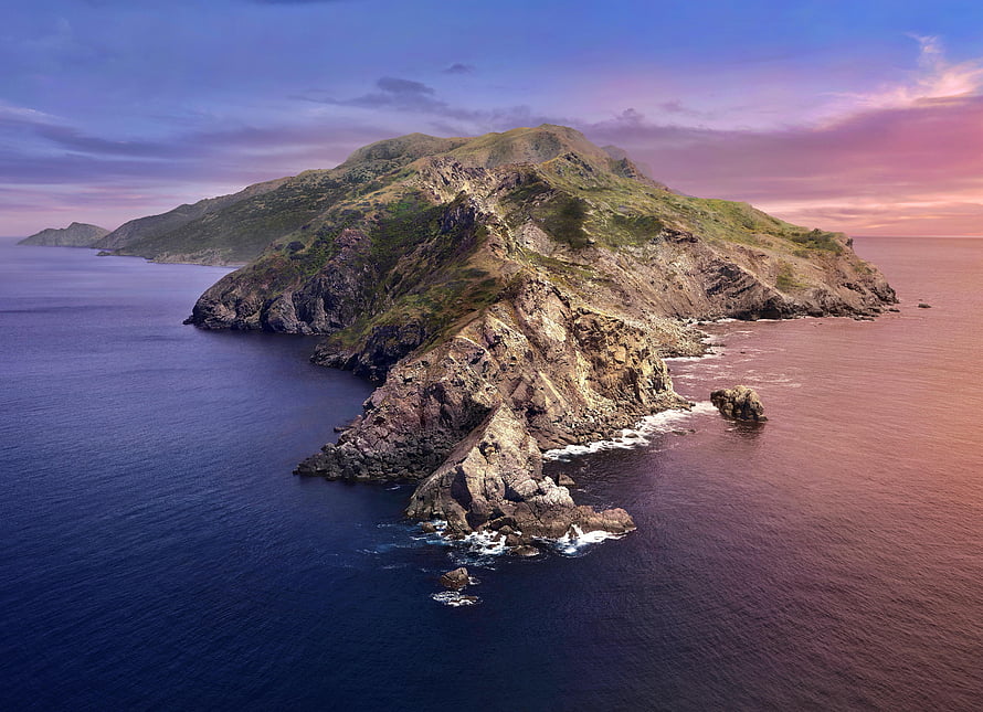 Aerial View of Rugged Coastal Island at Sunset with Dramatic Rocky Cliffs and Calm Ocean Waters HD wallpaper