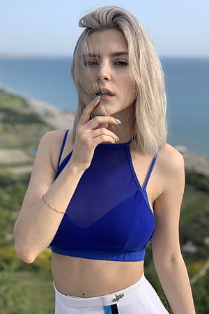 Blonde Woman in Blue Halter Top and White Pants by the Sea, Eva Elfie HD phone wallpaper