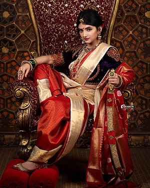 Sreeleela in Traditional Red and Gold Bridal Attire Seated on Ornate Throne HD phone wallpaper
