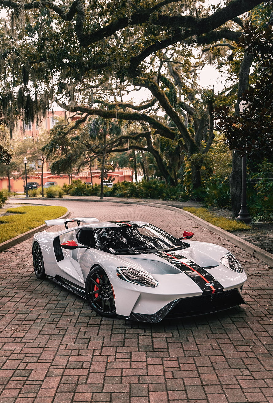 White Ford GT Supercar with Black and Red Stripes Parked on Brick Road HD phone wallpaper