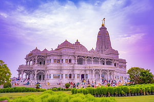 Grand White Marble Temple in Vrindavan with Intricate Carvings and Golden Spires Under a Purple Sky HD wallpaper