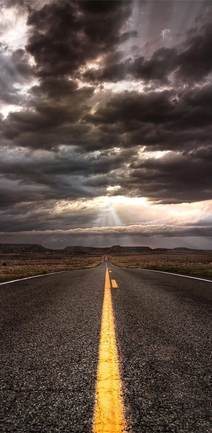 Dramatic Desert Highway Under Stormy Sky With Sunbeams Breaking Through Dark Clouds HD phone wallpaper