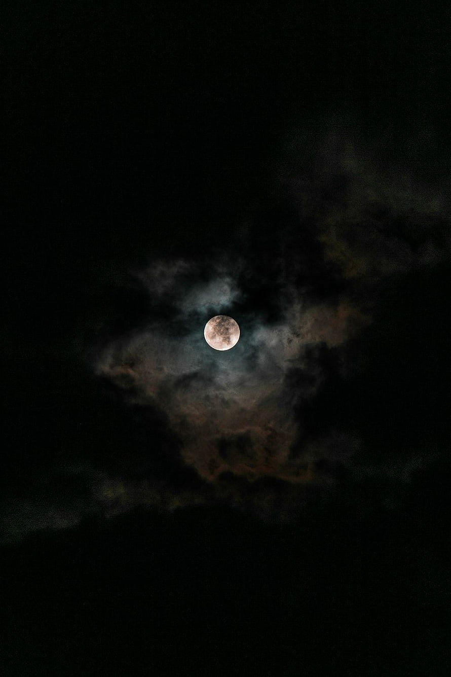 Full Moon Peeking Through Dark Clouds in a Mysterious Night Sky HD phone wallpaper