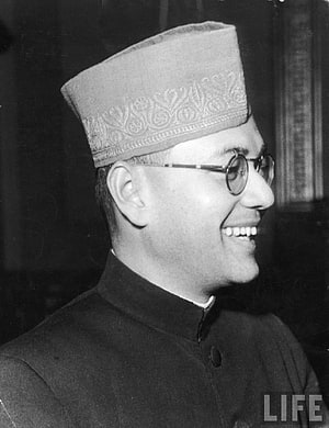 Subhas Chandra Bose in traditional cap and round glasses, smiling in profile HD phone wallpaper