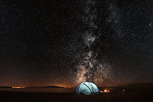 Camping Under The Milky Way Galaxy With Glowing Tent And Campfire HD wallpaper