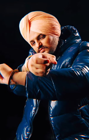 Diljit Dosanjh in a Blue Puffer Jacket and Peach Turban Pointing Forward HD phone wallpaper
