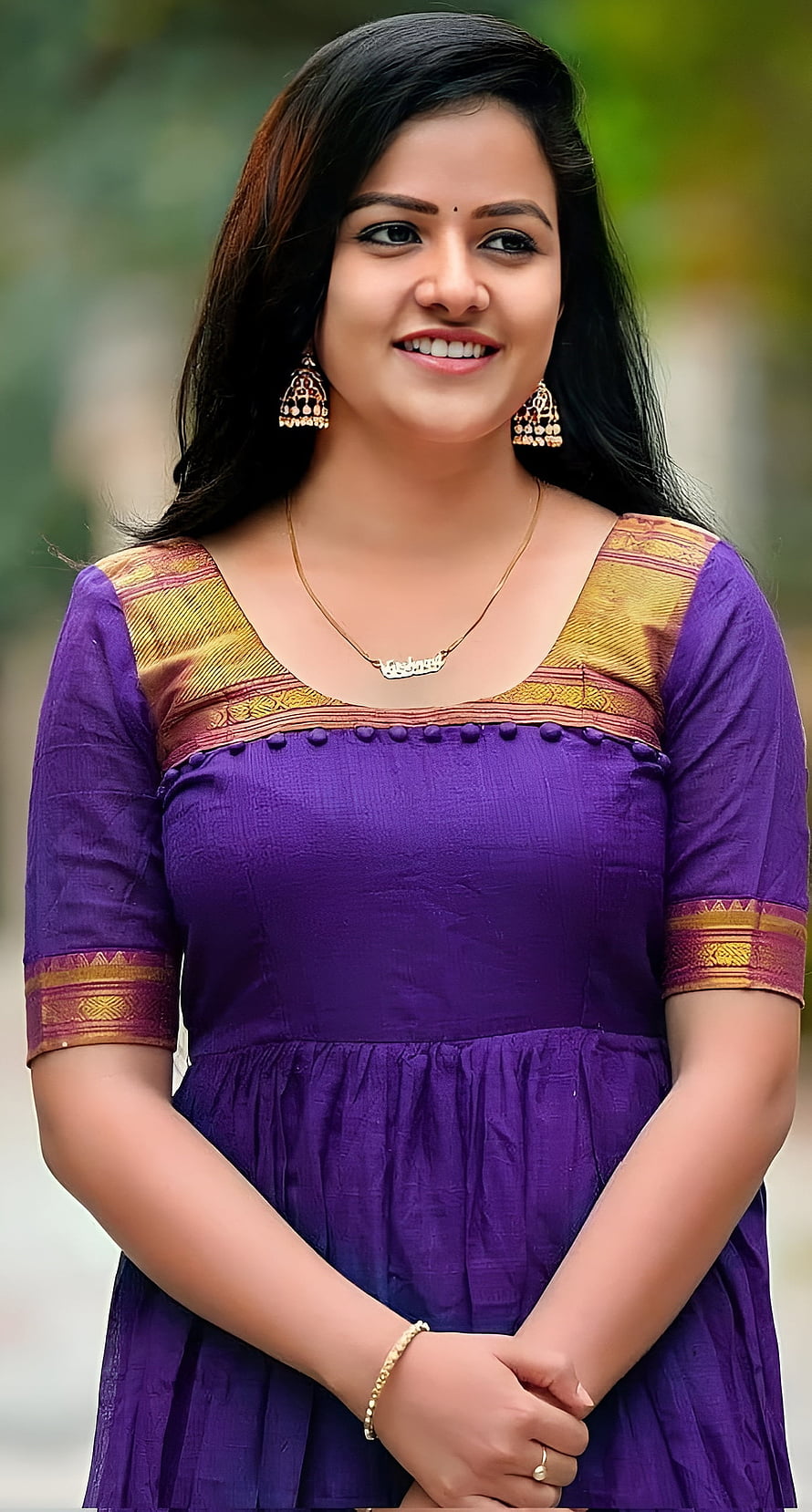 Vaishnavi Chaitanya in a purple traditional dress with gold jewelry and a warm smile HD phone wallpaper