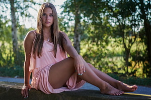 Young Woman in Pink Dress Sitting on Stone Wall in Sunlit Forest, Brunette, Girl, Beautiful, Beauty, Woman, Model, Lovely, Female HD wallpaper