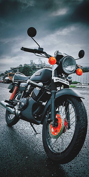 Yamaha RX100 Classic Motorcycle with Matte Black Finish and Orange Accents Under Stormy Sky HD phone wallpaper