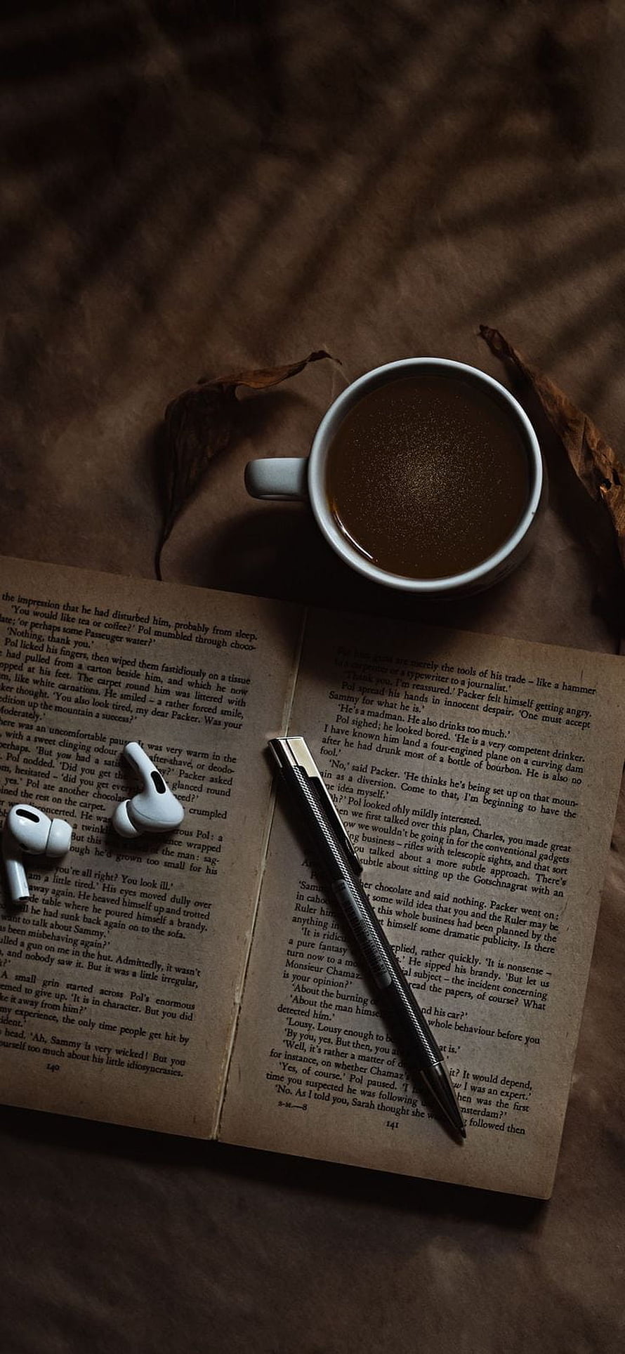 Cozy Reading Scene with Open Book, Coffee, and Wireless Earbuds HD phone wallpaper