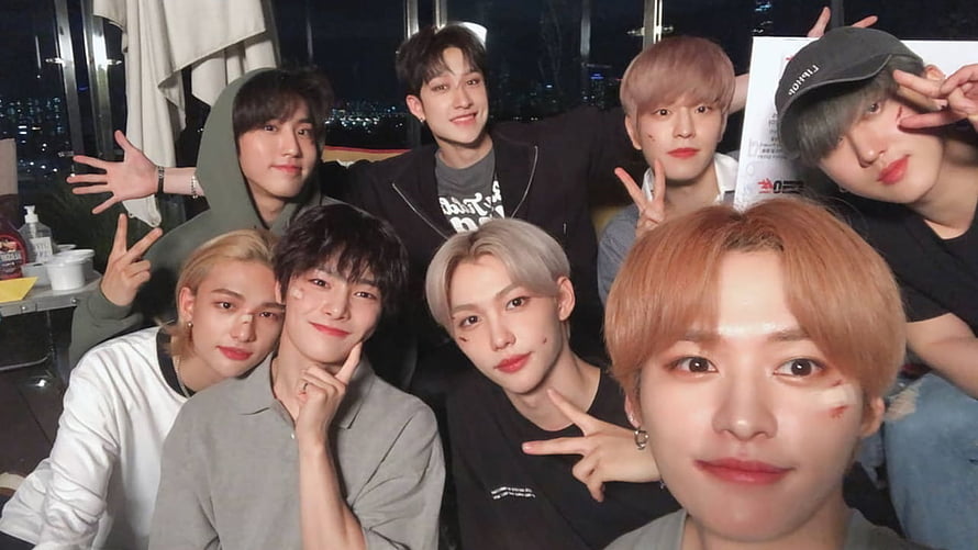 Stray Kids Group Selfie at Night with City Lights and Peace Signs HD wallpaper