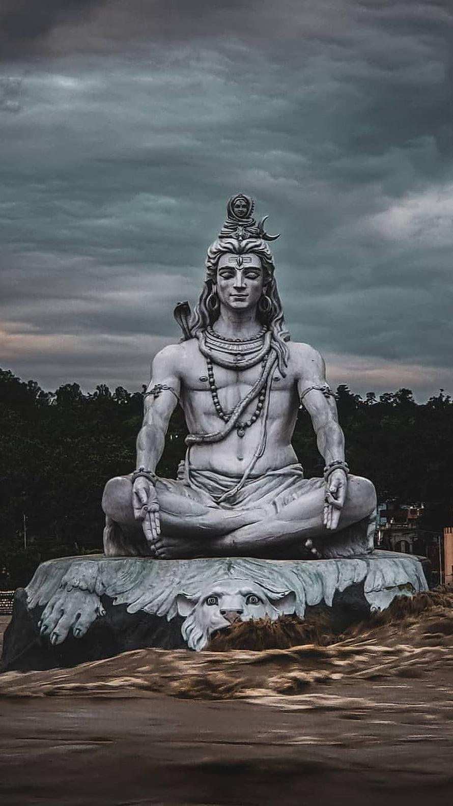 Majestic White Statue of Lord Shiva Meditating on a Rock Under Stormy Sky HD phone wallpaper