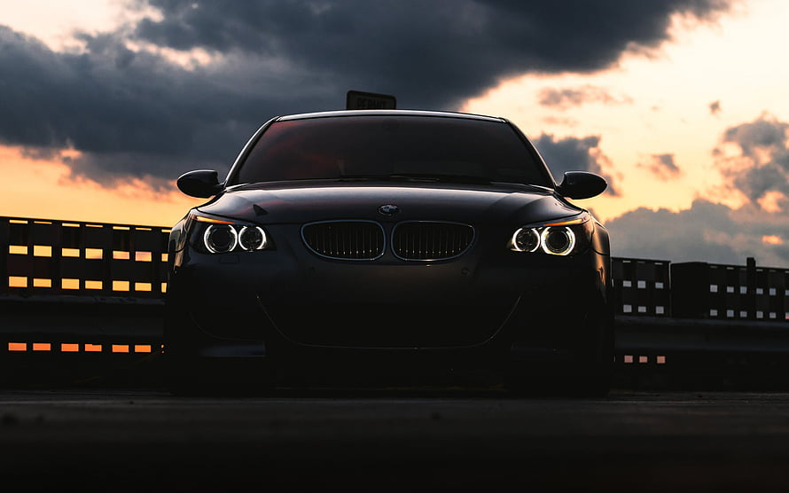 Black BMW 1 Series with Angel Eyes Headlights Parked on Bridge at Sunset HD wallpaper