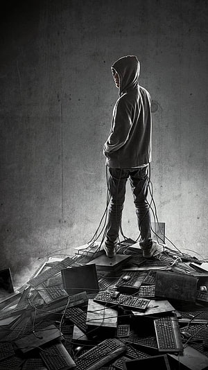 Hacker in Hoodie Standing on Pile of Broken Computers and Keyboards HD phone wallpaper