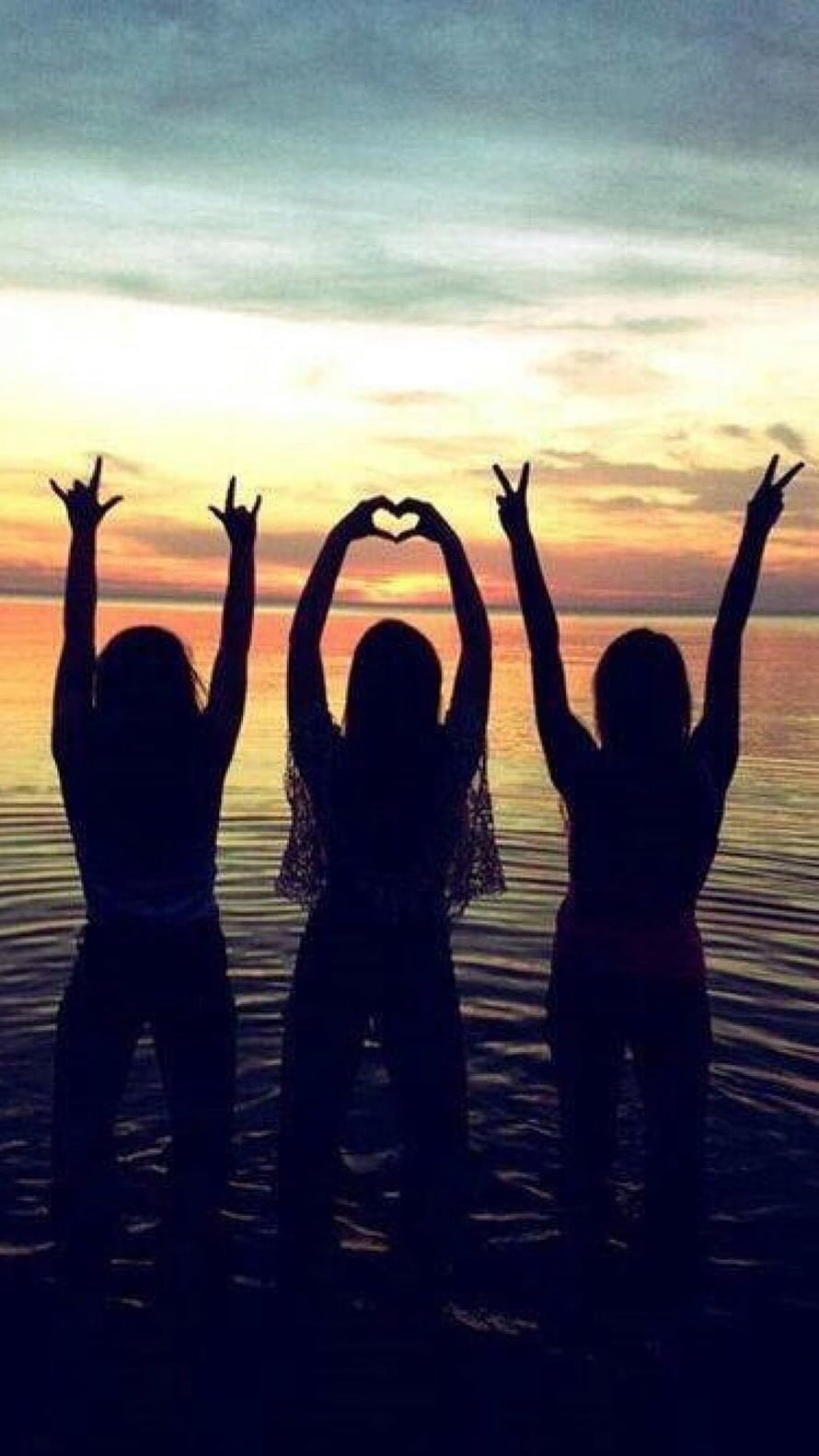 Three Silhouetted Friends Making Hand Gestures Against a Sunset Ocean View HD phone wallpaper