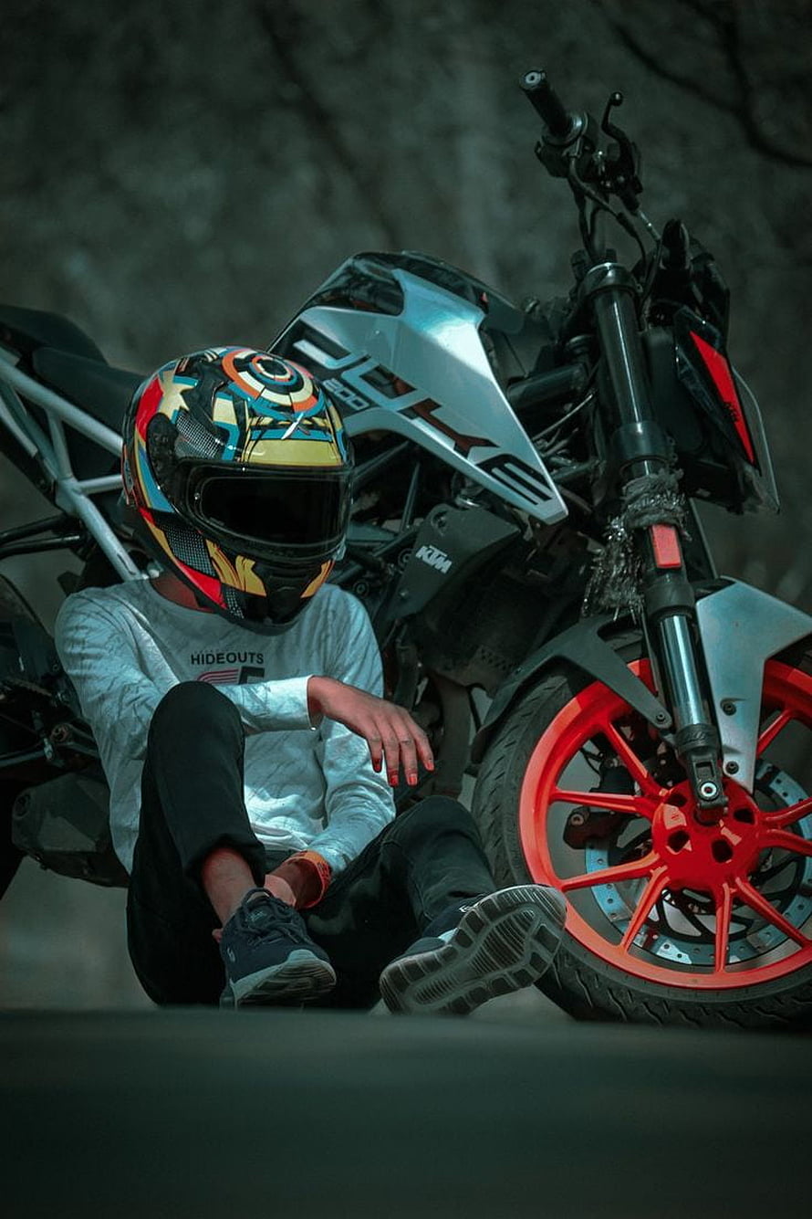 Biker Sitting on Ground Next to KTM Duke 200 Motorcycle with Colorful Helmet HD phone wallpaper