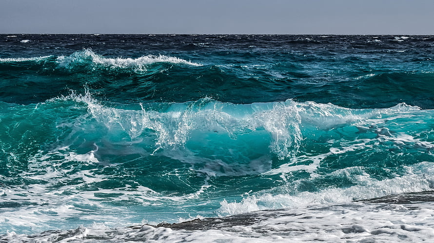 Dynamic Turquoise Ocean Waves Crashing with White Sea Foam on Rocky Shoreline HD wallpaper