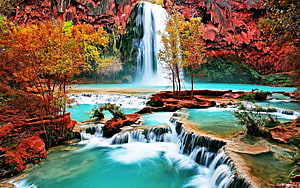 Stunning turquoise waterfall cascading over red rocks with autumn foliage HD wallpaper