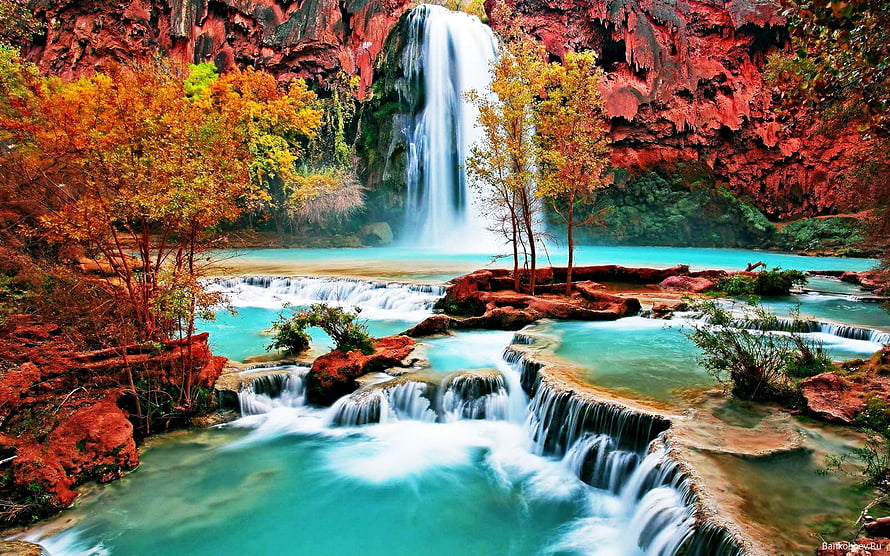 Stunning turquoise waterfall cascading over red rocks with autumn foliage HD wallpaper