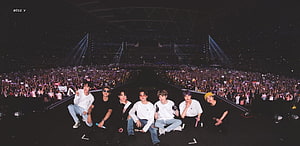 BTS Members Sitting On Stage At A Massive Stadium Concert With A Huge Crowd HD wallpaper