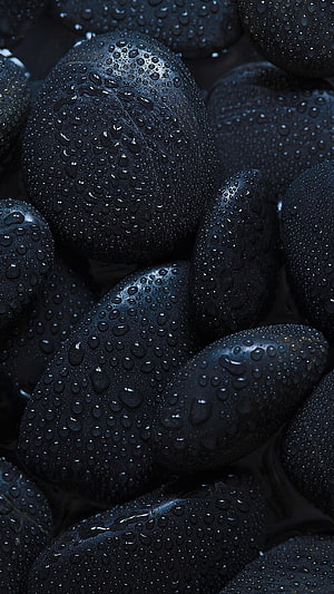 Close-up of wet black stones with water droplets for a dark and moody aesthetic HD phone wallpaper